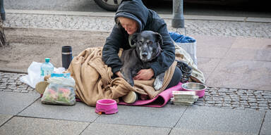 Frau mit Hund bettelt um Geld 