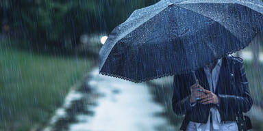 Frau mit Regenschirm im Regen