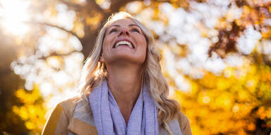 Frau genießt Sonne im Herbst