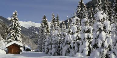 Schneelandschaft in den bergen mit einsamer huette